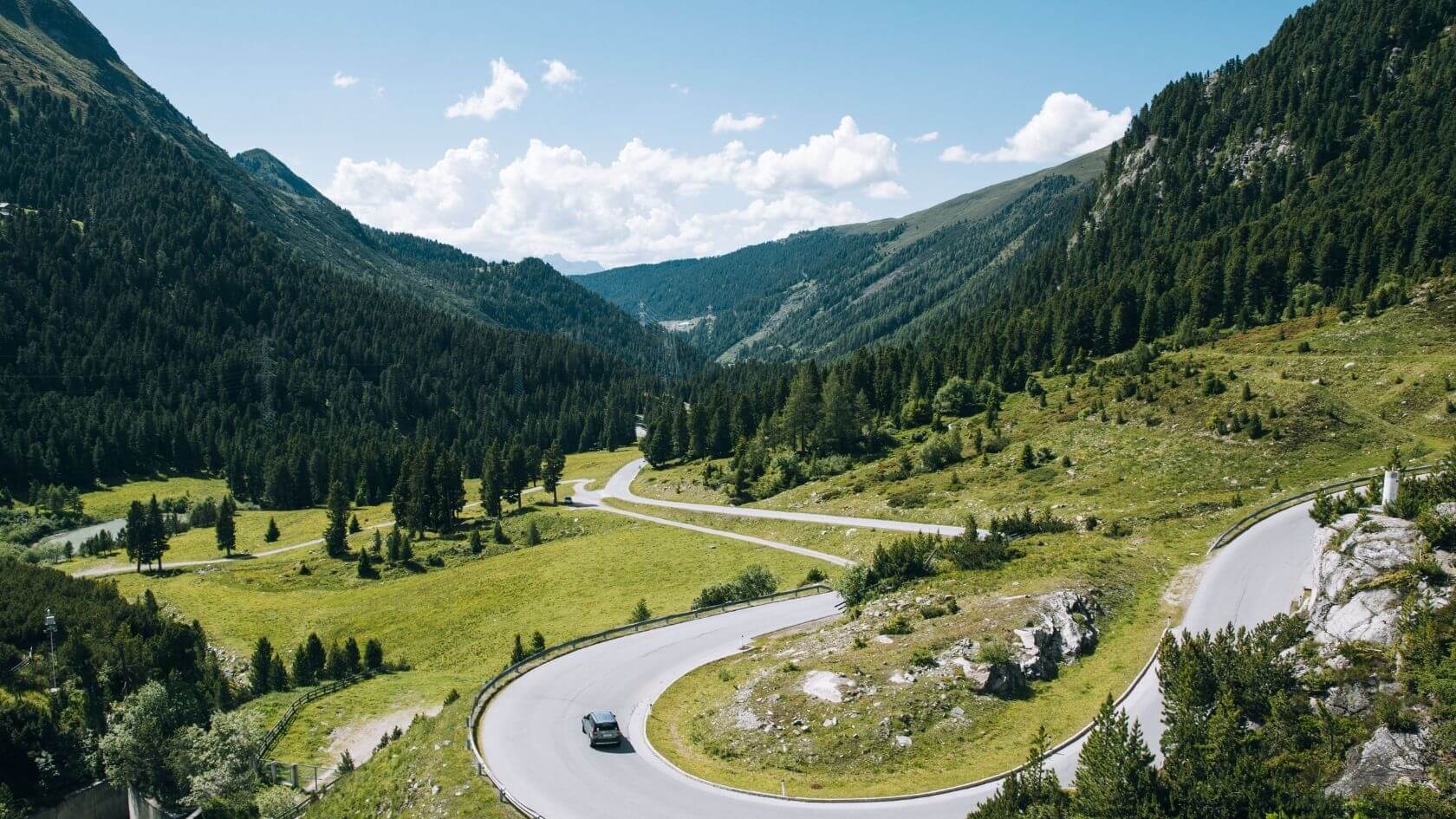 Een prachtig uitzicht op een kronkelende weg door de weelderig groene bergen en valleien van Tirol, Oostenrijk